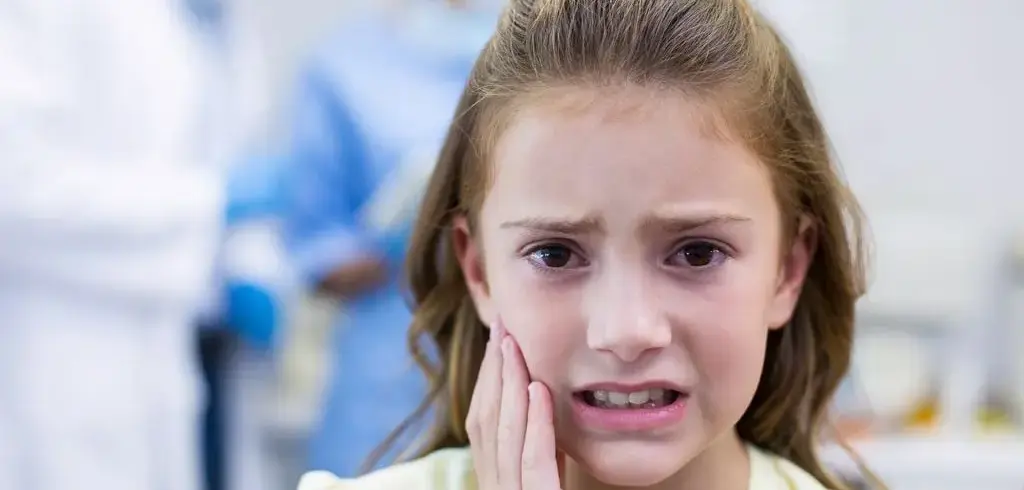 Child With Tooth Pain Holding Mouth