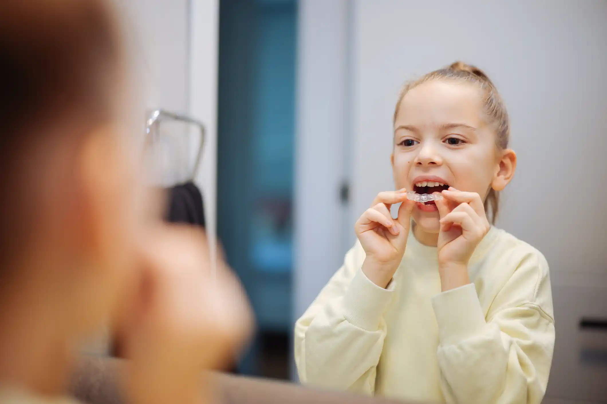 Girl with clear aligners for straight teeth.